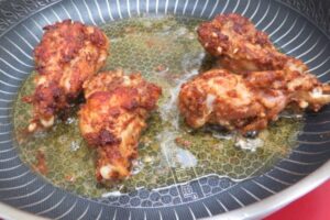 chicken wings in a pan with oil