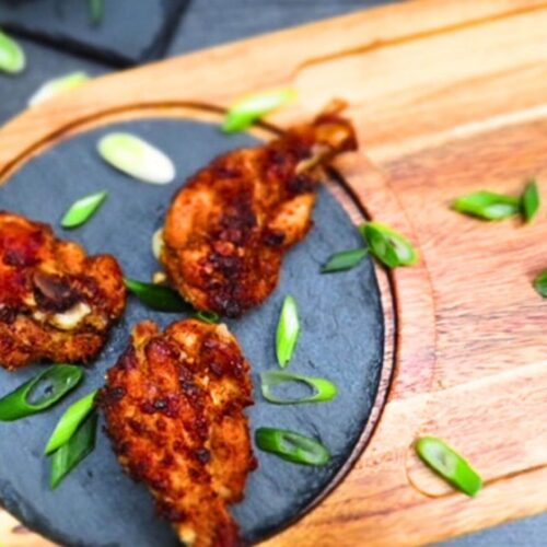 five spice chicken wings on stone and wooden board