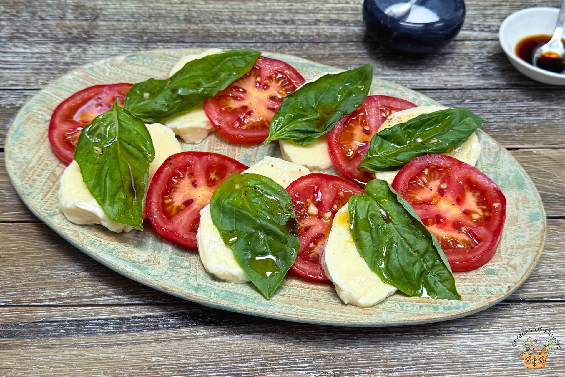 easy caprese salad on a green plate with orange vinaigrette