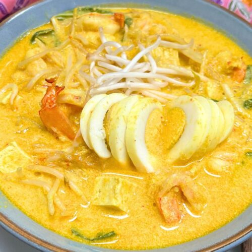 laksa lemak with a boiled egg in a blue bowl