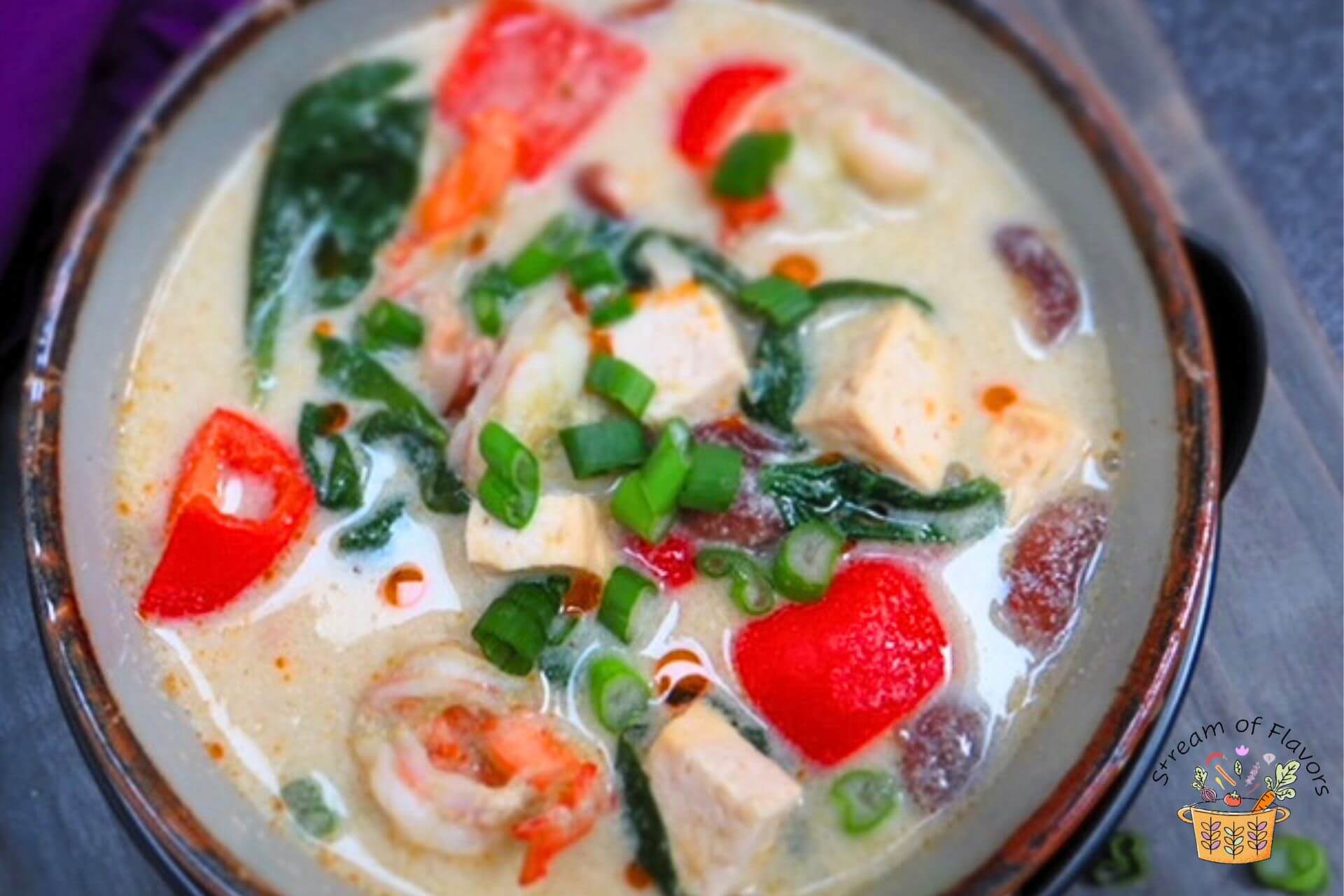 tom kha goong in a bowl with scallions