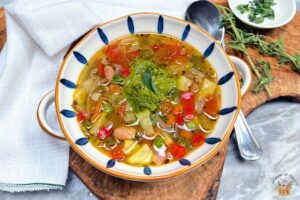 Provencal vegetable soup in a blue and white bowl with pistou
