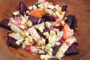 roasted beet and fennel salad with walnuts in a wooden bowl