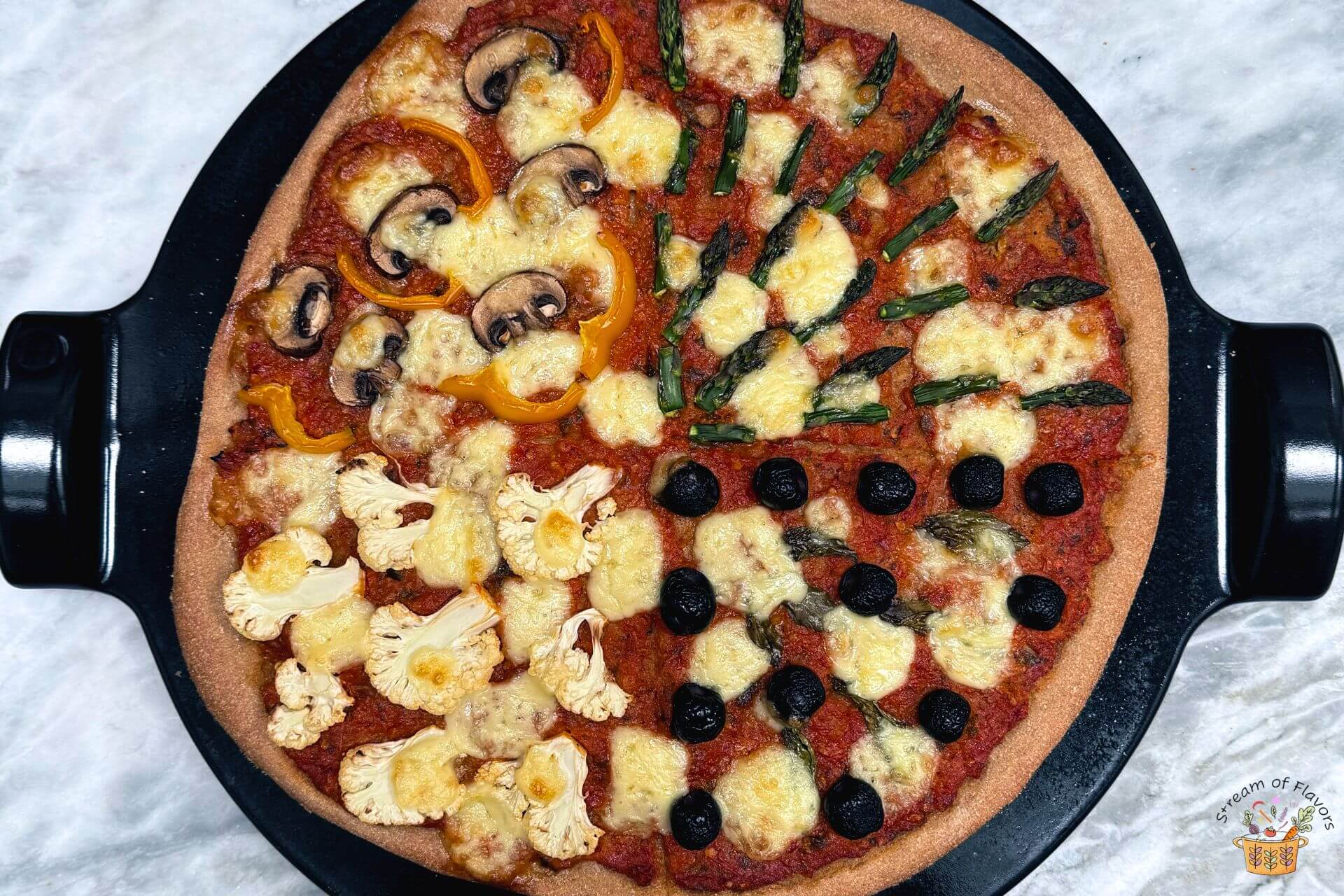 four seasons pizza on a black pizza stone