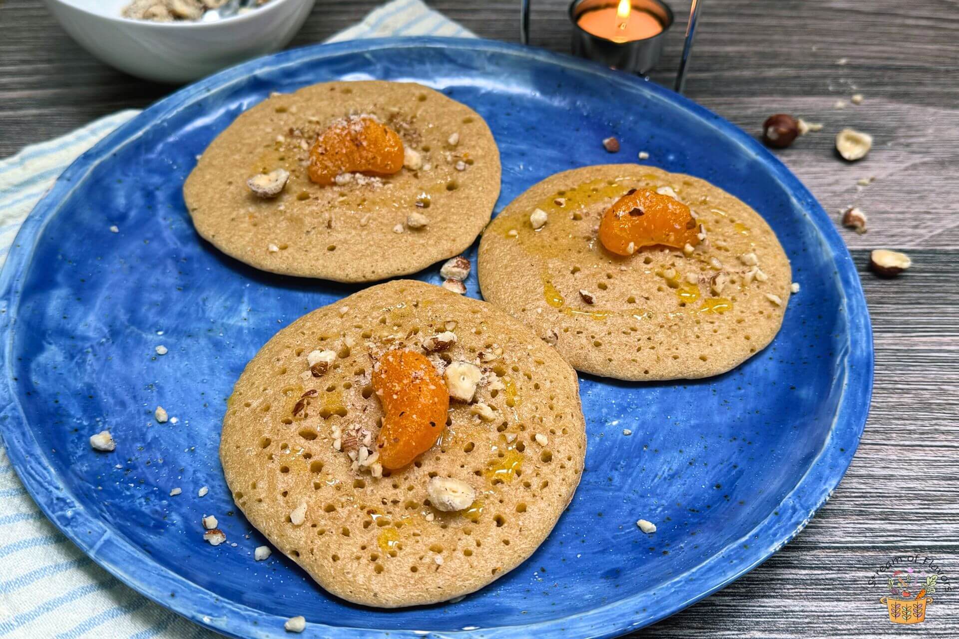 Moroccan semolina pancakes with orange segments and sauce in a blue plate