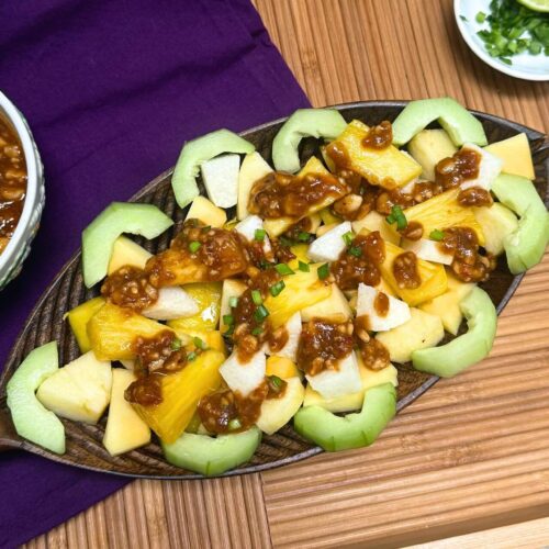 rujak recipe in a bamboo platter with peanut sauce in a bowl on the side