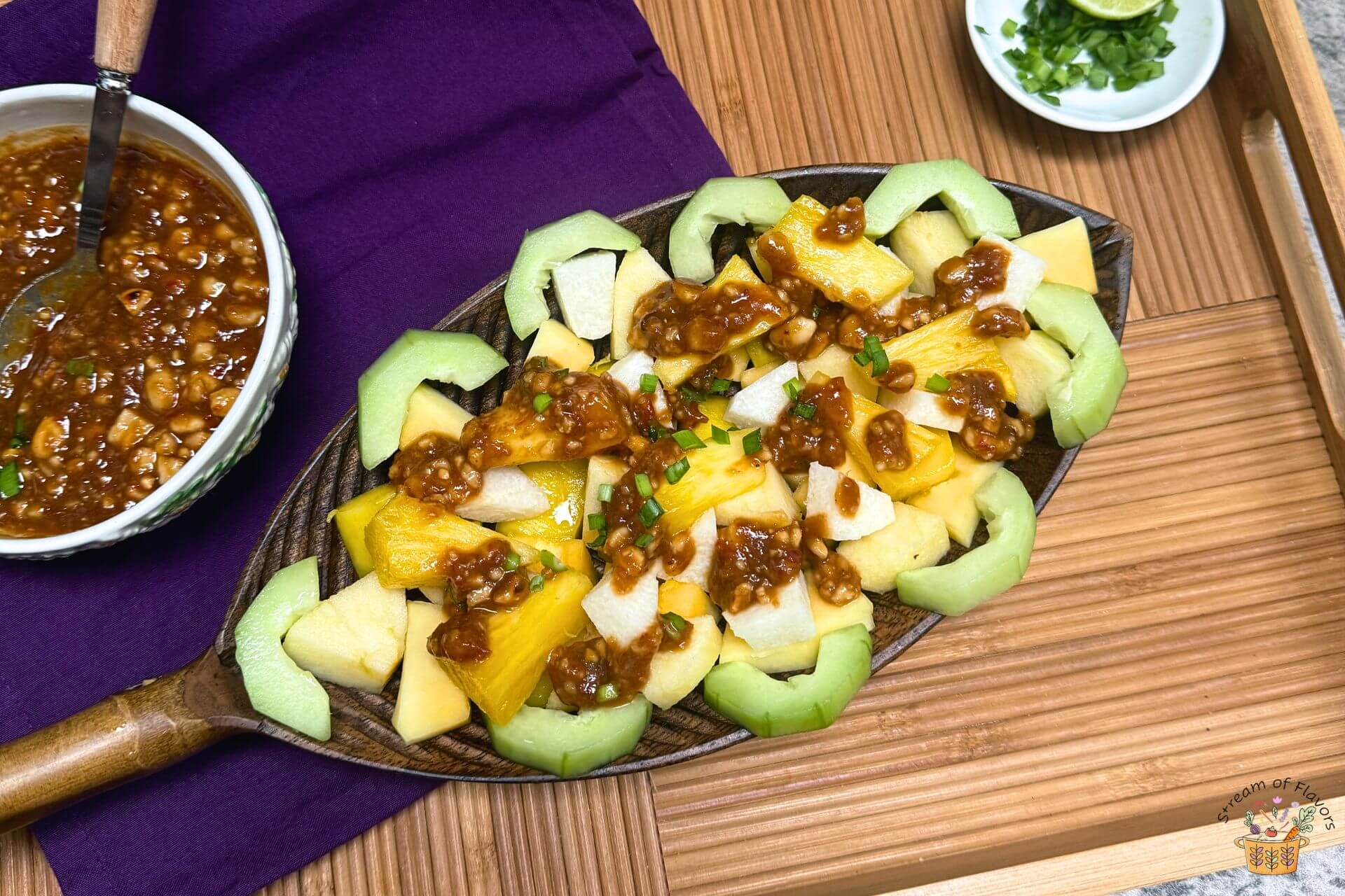 rujak recipe in a bamboo platter with peanut sauce in a bowl on the side