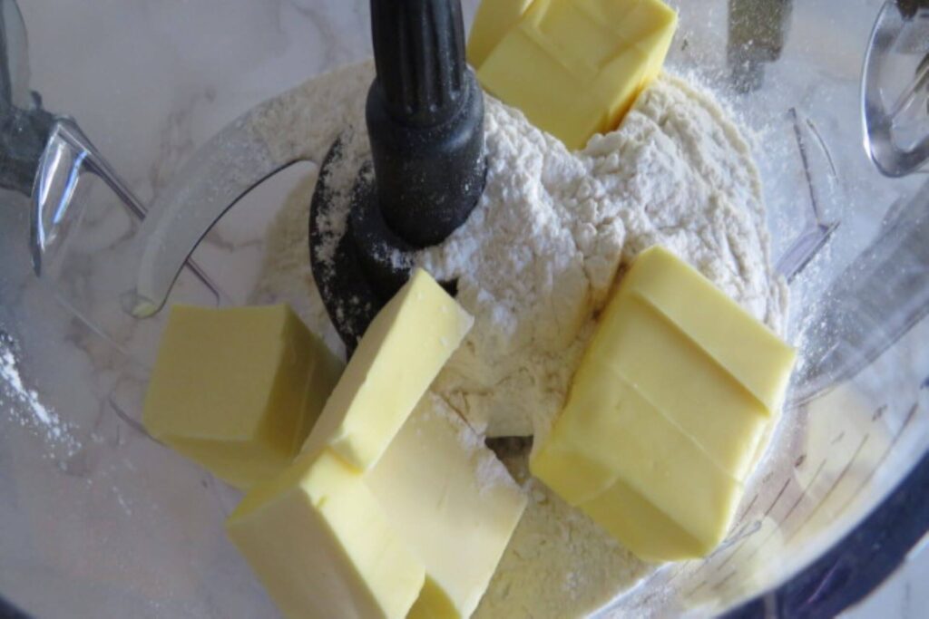 flour with butter pieces in a food processor