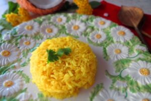nasi kuning on a plate with cilantro on top