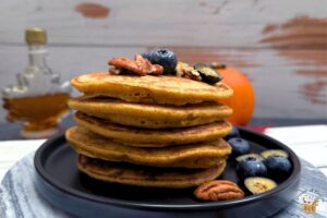 whole wheat pumpkin pancakes with blueberries and pecans on top