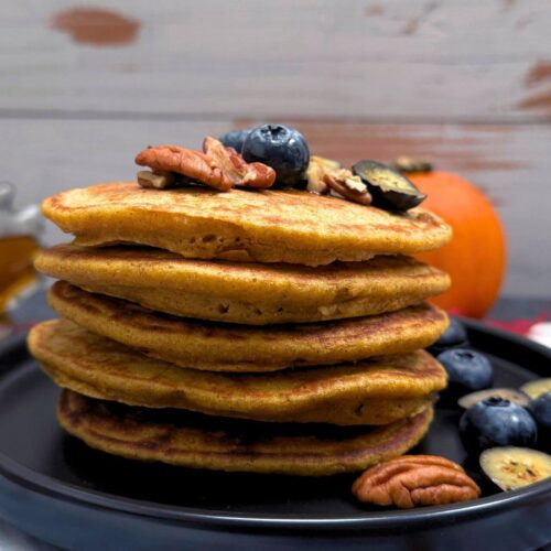 whole wheat pumpkin pancakes with blueberries and pecans on top