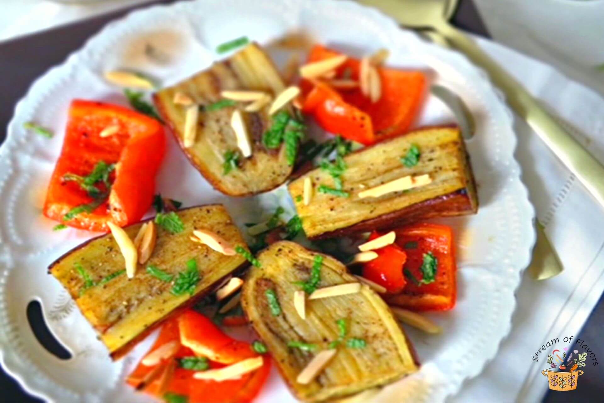 Roasted eggplant and peppers on a plate with almonds