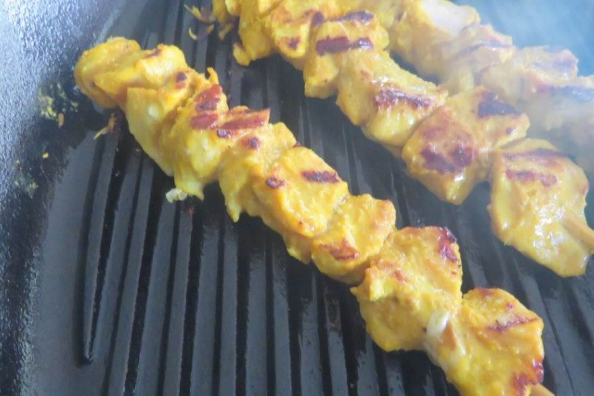 flipped chicken skewers on the skillet