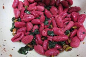 beetroot gnocchi with kale on a plate