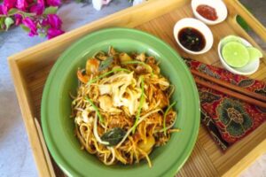 mamak mee goreng recipe with sauces on side in a green bowl