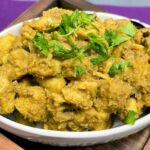 chicken rendang in a white bowl with cilantro garnish