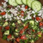 tabbouleh with quinoa garnished with shallot and cucumber slices