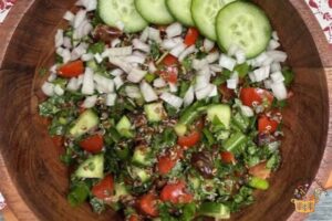 tabbouleh with quinoa garnished with shallot and cucumber slices