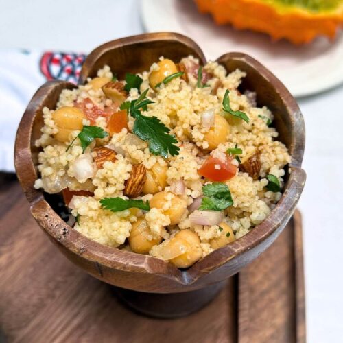 moroccan couscous salad in a wooden bowl with kiwano