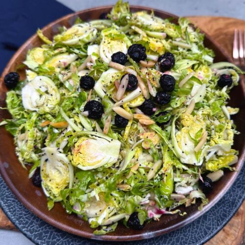 shaved brussels sprouts salad in a wooden bowl