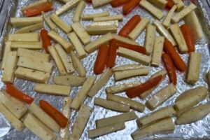 parsnips and carrots strips on a foil lined tray