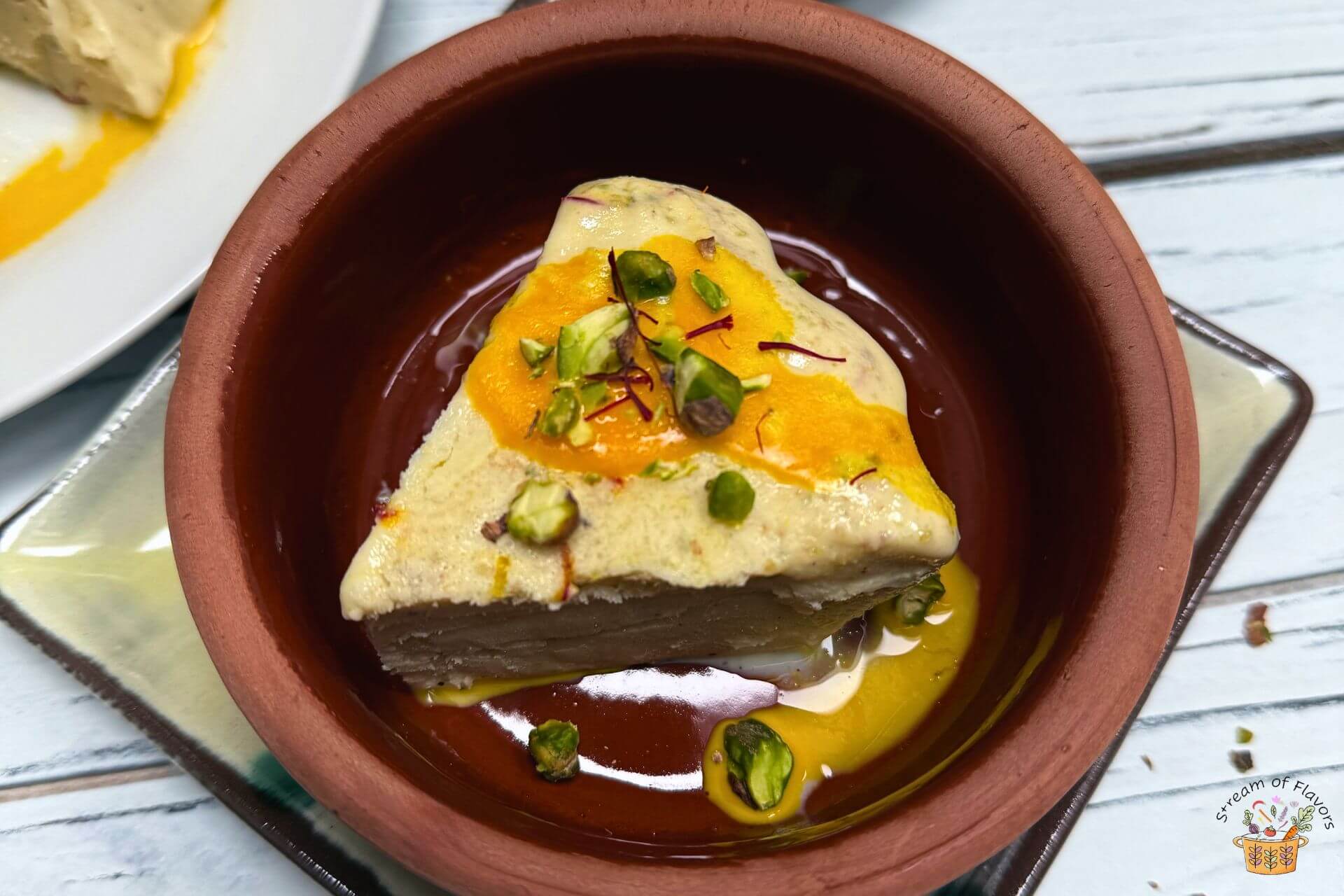 kesar pista kulfi slice in a clay bowl with pistachio on top