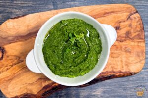 hazelnut pesto in a white bowl with olive oil drizzled on top