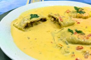 homemade lobster ravioli with cashew-saffron sauce and garnished with parsley