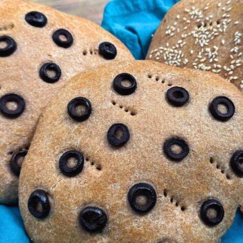 khobz recipe topped with sliced olives and sesame seeds