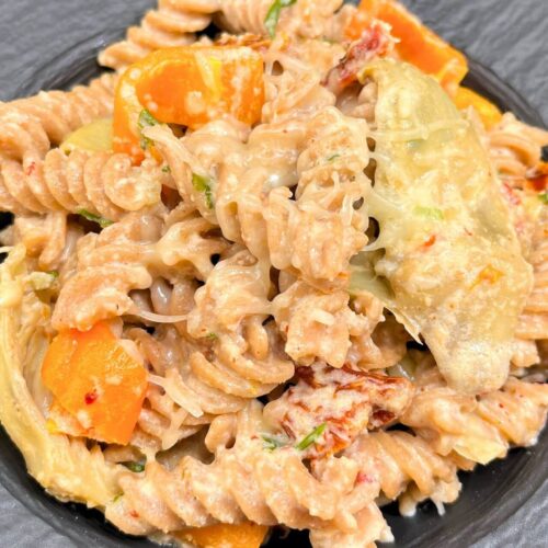 quick pasta with cheese and peppers in a black bowl