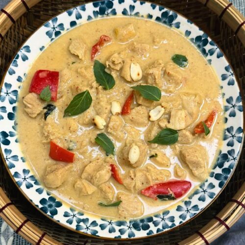 Panang chicken curry made with my recipe in a bowl garnished with basil leaves
