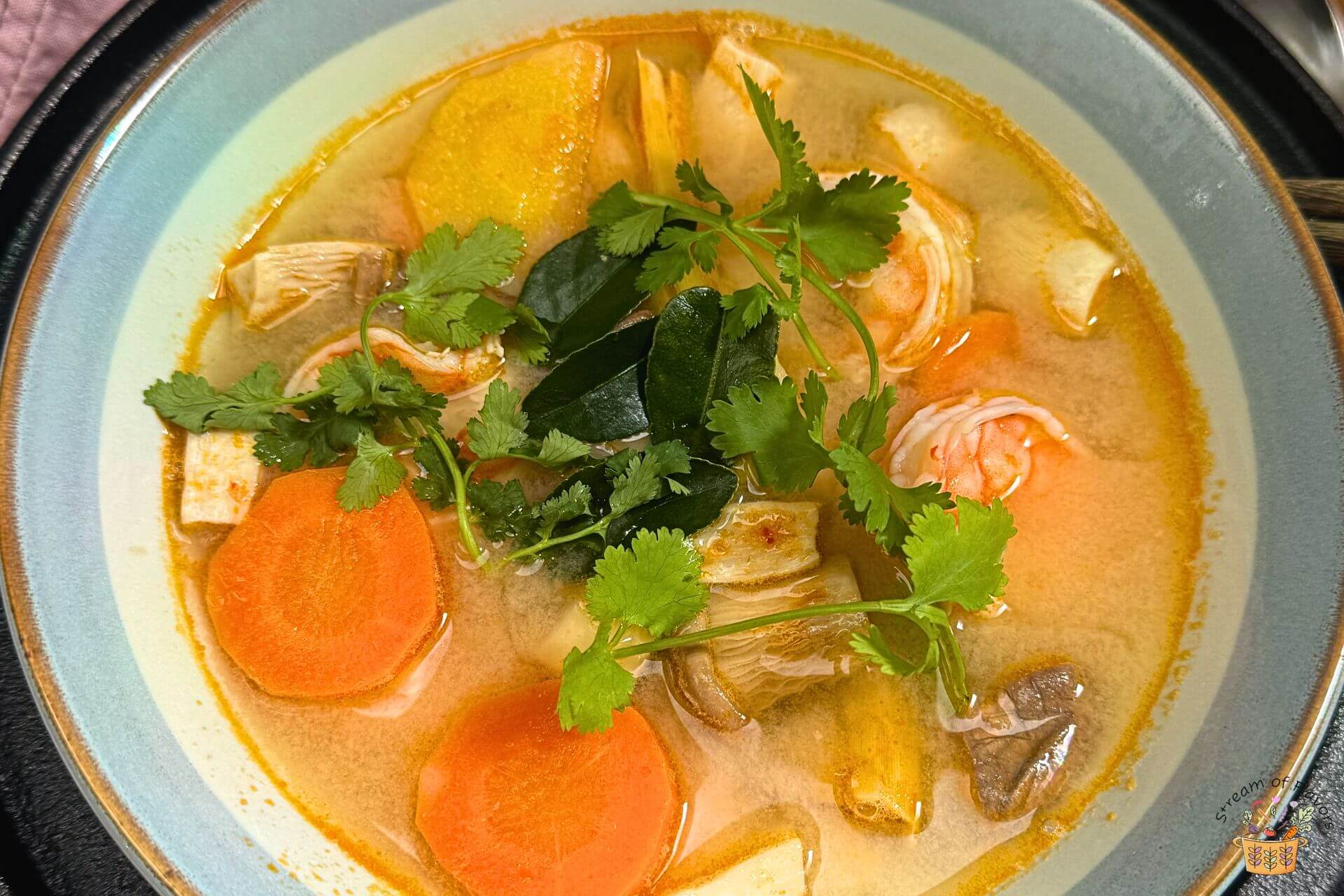 Tom yum goong recipe in a bowl with cilantro