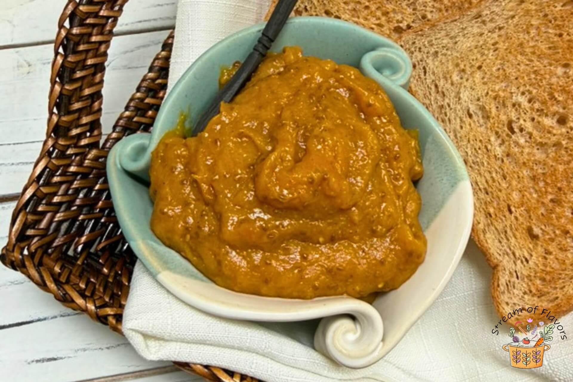 sugar free mango jam in a light blue bowl with a slice of bread